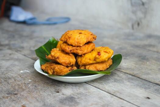 un pila de tofu buñuelos o frito tofu un pan en un hoja lámina. hecho desde un mezcla machacado tofu, un pequeño tapioca harina, verde cebollas, huevos, sal y pimienta. crujiente en el afuera, suave en el dentro foto