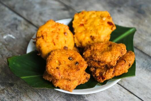 un pila de tofu buñuelos o frito tofu un pan en un hoja lámina. hecho desde un mezcla machacado tofu, un pequeño tapioca harina, verde cebollas, huevos, sal y pimienta. crujiente en el afuera, suave en el dentro foto