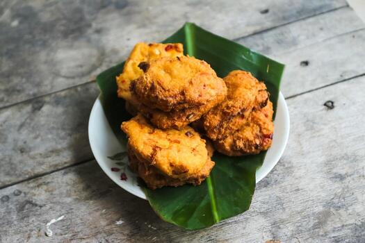 un pila de tofu buñuelos o frito tofu un pan en un hoja lámina. hecho desde un mezcla machacado tofu, un pequeño tapioca harina, verde cebollas, huevos, sal y pimienta. crujiente en el afuera, suave en el dentro foto