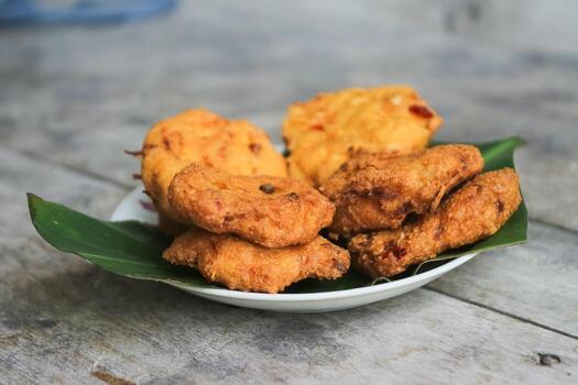 un pila de tofu buñuelos o frito tofu un pan en un hoja lámina. hecho desde un mezcla machacado tofu, un pequeño tapioca harina, verde cebollas, huevos, sal y pimienta. crujiente en el afuera, suave en el dentro foto