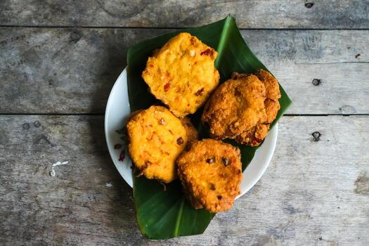 un pila de tofu buñuelos o frito tofu un pan en un hoja lámina. hecho desde un mezcla, machacado tofu, un pequeño tapioca harina, verde cebollas, huevos, sal y pimienta. crujiente en el afuera, suave en el dentro foto