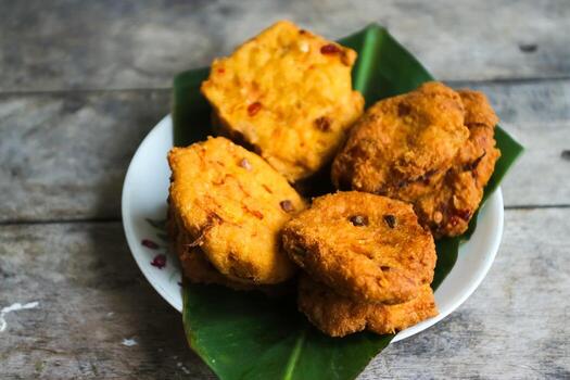 un pila de tofu buñuelos o frito tofu un pan en un hoja lámina. hecho desde un mezcla machacado tofu, un pequeño tapioca harina, verde cebollas, huevos, sal y pimienta. crujiente en el afuera, suave en el dentro foto