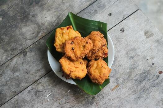 un pila de tofu buñuelos o frito tofu un pan en un hoja lámina. hecho desde un mezcla, machacado tofu, un pequeño tapioca harina, verde cebollas, huevos, sal y pimienta. crujiente en el afuera, suave en el dentro foto