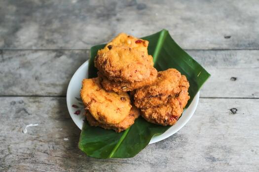 un pila de tofu buñuelos o frito tofu un pan en un hoja lámina. hecho desde un mezcla machacado tofu, un pequeño tapioca harina, verde cebollas, huevos, sal y pimienta. crujiente en el afuera, suave en el dentro foto