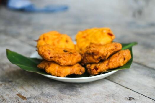 un pila de tofu buñuelos o frito tofu un pan en un hoja lámina. hecho desde un mezcla machacado tofu, un pequeño tapioca harina, verde cebollas, huevos, sal y pimienta. crujiente en el afuera, suave en el dentro foto