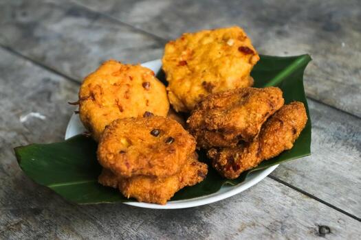 un pila de tofu buñuelos o frito tofu un pan en un hoja lámina. hecho desde un mezcla machacado tofu, un pequeño tapioca harina, verde cebollas, huevos, sal y pimienta. crujiente en el afuera, suave en el dentro foto