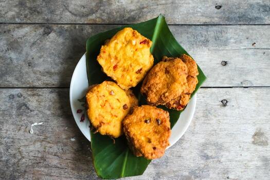 un pila de tofu buñuelos o frito tofu un pan en un hoja lámina. hecho desde un mezcla, machacado tofu, un pequeño tapioca harina, verde cebollas, huevos, sal y pimienta. crujiente en el afuera, suave en el dentro foto