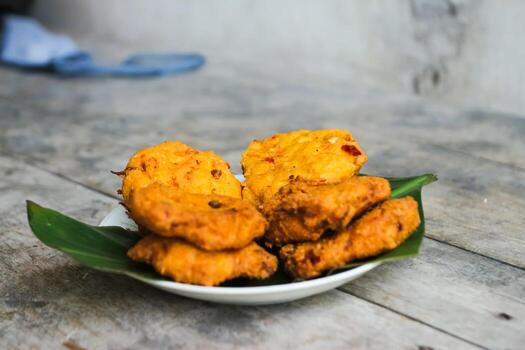 un pila de tofu buñuelos o frito tofu un pan en un hoja lámina. hecho desde un mezcla machacado tofu, un pequeño tapioca harina, verde cebollas, huevos, sal y pimienta. crujiente en el afuera, suave en el dentro foto