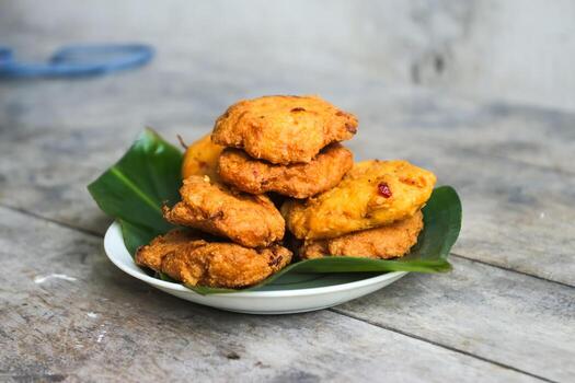 un pila de tofu buñuelos o frito tofu un pan en un hoja lámina. hecho desde un mezcla machacado tofu, un pequeño tapioca harina, verde cebollas, huevos, sal y pimienta. crujiente en el afuera, suave en el dentro foto
