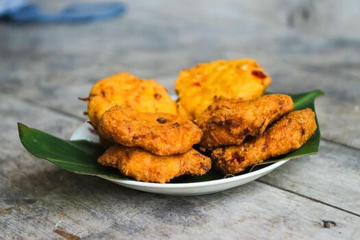 un pila de tofu buñuelos o frito tofu un pan en un hoja lámina. hecho desde un mezcla machacado tofu, un pequeño tapioca harina, verde cebollas, huevos, sal y pimienta. crujiente en el afuera, suave en el dentro foto