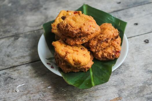 un pila de tofu buñuelos o frito tofu un pan en un hoja lámina. hecho desde un mezcla machacado tofu, un pequeño tapioca harina, verde cebollas, huevos, sal y pimienta. crujiente en el afuera, suave en el dentro foto