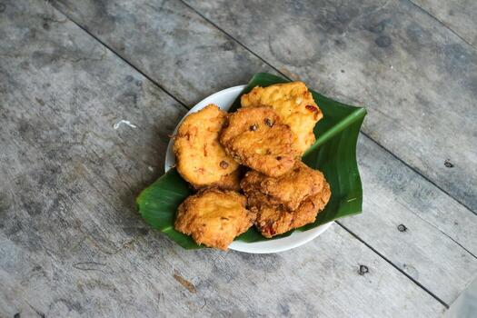 un pila de tofu buñuelos o frito tofu un pan en un hoja lámina. hecho desde un mezcla, machacado tofu, un pequeño tapioca harina, verde cebollas, huevos, sal y pimienta. crujiente en el afuera, suave en el dentro foto