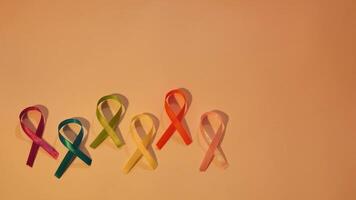 Cancer disease symbol with colored ribbons, light close-up on world Cancer Awareness Day. Medical concept, background, top view video