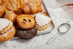 Collection of cakes and different pies with cheese, apple, cherry, meat and cabbage on a plate. Bakery goods. Sweet pastries. photo