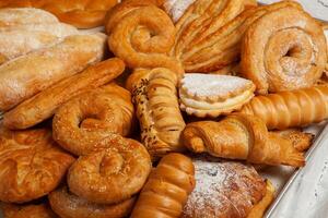 Collection of cakes and different pies with cheese, apple, cherry, meat and cabbage on a plate. Bakery goods. Sweet pastries. photo