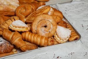 Collection of cakes and different pies with cheese, apple, cherry, meat and cabbage on a plate. Bakery goods. Sweet pastries. photo