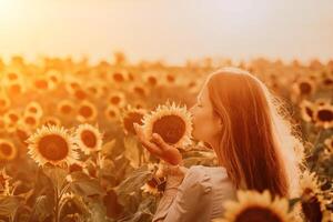 Woman in Sunflower Field. Happy girl in a straw hat posing in a vast field of sunflowers at sunset, enjoy taking picture outdoors for memories. Summer time. photo