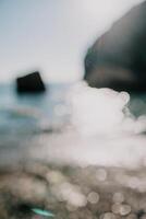 Abstract nature summer ocean sunset sea background. Small waves on water surface in motion blur with bokeh lights from sunrise. Holiday, vacation and recreational background concept. photo