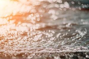 Blurred golden sea at sunset. The sun reflects and sparkles on the waves with bokeh, illuminating the golden sea. Holiday recreation concept. Abstract nautical summer ocean sunset nature background. photo