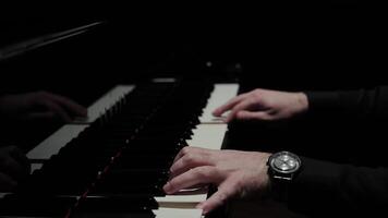 Playing the piano in a dark hall. Hands press the piano keys video