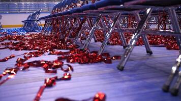 rows of empty blue chairs. red Confetti and tinsel on the floor video