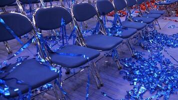 red and blue Confetti and tinsel on the floor. rows of empty blue chairs video