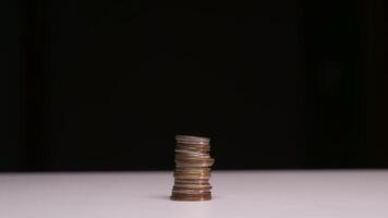 Stop motion animation timelaps stack of coins growing on black background video