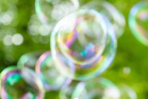 soap bubbles close-up on a background of sun and greenery, abstract background, positive mood, holiday, carelessness photo