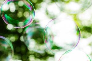 soap bubbles close-up on a background of sun and greenery, abstract background, positive mood, holiday, carelessness photo