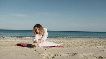 Girl Dressed In White Does Stretching On The Beach Near The Ocean video