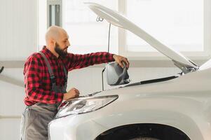 Oil is replaced in a car engine by a qualified auto mechanic in a service center to increase engine life, including draining used oil, refueling with high-quality oil and level control. photo