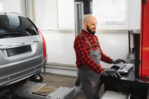 working process of a full system diagnostic scanner that can quickly test every system module s status and make faster diagnosis. mechanic makes computer diagnostics of the car photo