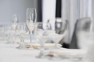 Glasses on the festive table setting. Wedding table decor concept. Table setting in classic style, setout. fine art. photo