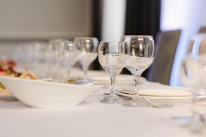 Glasses on the festive table setting. Wedding table decor concept. Table setting in classic style, setout. fine art. photo