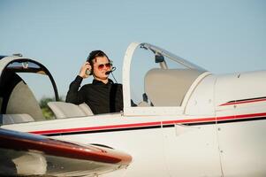 Portrait of confident young man pilot in small plane photo