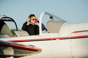 Young pilot is preparing for take off with private plane. photo