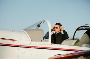 Portrait of confident young man pilot in small plane photo