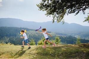 Children pilot aviator with airplane dreams of traveling in summer in nature. Vacation concept. photo