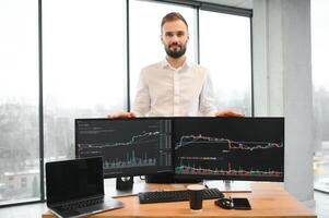 Crypto trader sits at his workplace in front of a monitor with charts. photo