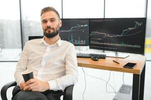 Crypto trader sits at his workplace in front of a monitor with charts. photo