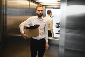 Man by dismissal. Guy lost job. Fired manager in company. Dismissal box in hands of employee. photo