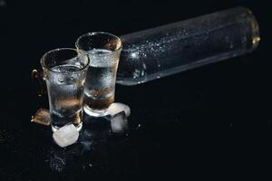 Vodka. Shots, glasses with vodka with ice .Dark background. Copy space .Selective focus. photo