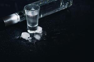 Vodka. Shots, glasses with vodka with ice .Dark background. Copy space .Selective focus. photo