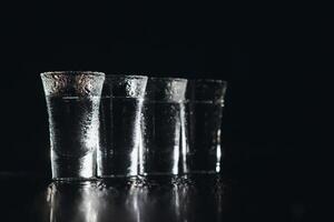 Vodka. Shots, glasses with vodka with ice .Dark background. Copy space .Selective focus. photo