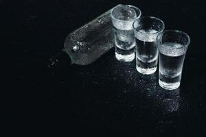 Vodka. Shots, glasses with vodka with ice .Dark background. Copy space .Selective focus. photo