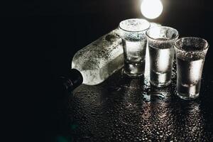 Vodka. Shots, glasses with vodka with ice .Dark background. Copy space .Selective focus. photo