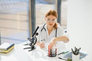 Doctor woman working a microscope. Female scientist looking through a microscope in lab. Student looking in a microscope, science laboratory concept photo