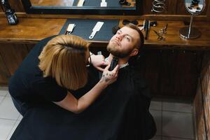 cliente durante barba afeitado en Barbero tienda foto