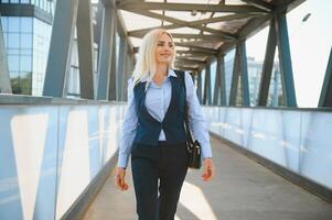 Beautiful Woman Going To Work, Business Woman Walking Near Office Building. Portrait Of Successful Business Woman. photo