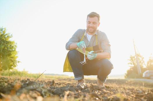 enguantado manos y palas pala el suelo.a mano en un blanco jardinería guante trabajos con un herramienta. foto